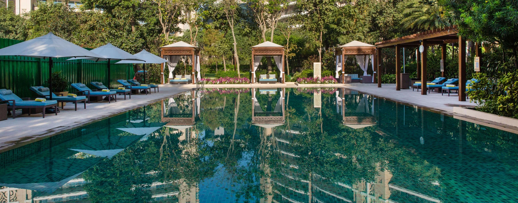 DLF The Magnolias — residents' pool and landscaped deck — Residents' clubhouse reference, not the offered home. Membership, access and charges are governed by current terms.