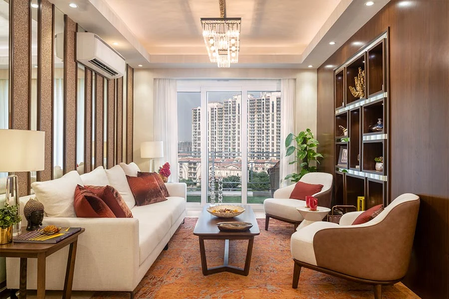 DLF The Skycourt — furnished living-room reference — Developer gallery photograph of a furnished reference home, not the offered unit. Furniture, appliances and finishes are not included unless agreed.